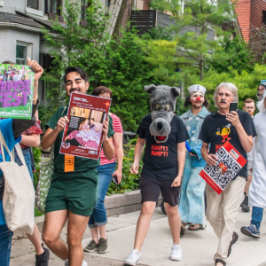 Fringe artists parade on the street holding posters and cheering