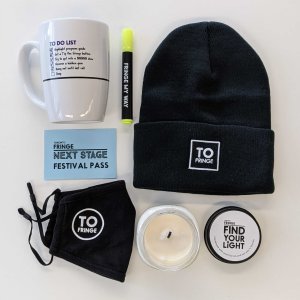 Gift package showing a Fringe mug, highlighter, black toque, mask, candle, and a Next Stage Festival Pass