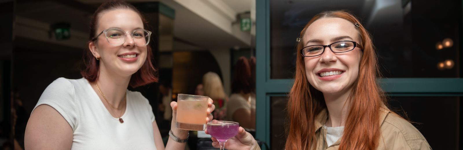 Two young donors cheers their glasses and smile at the camera