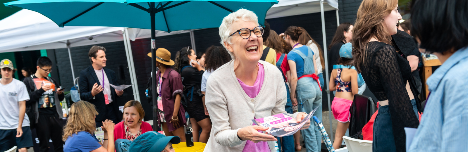 A patron laughs while looking at an artist's poster