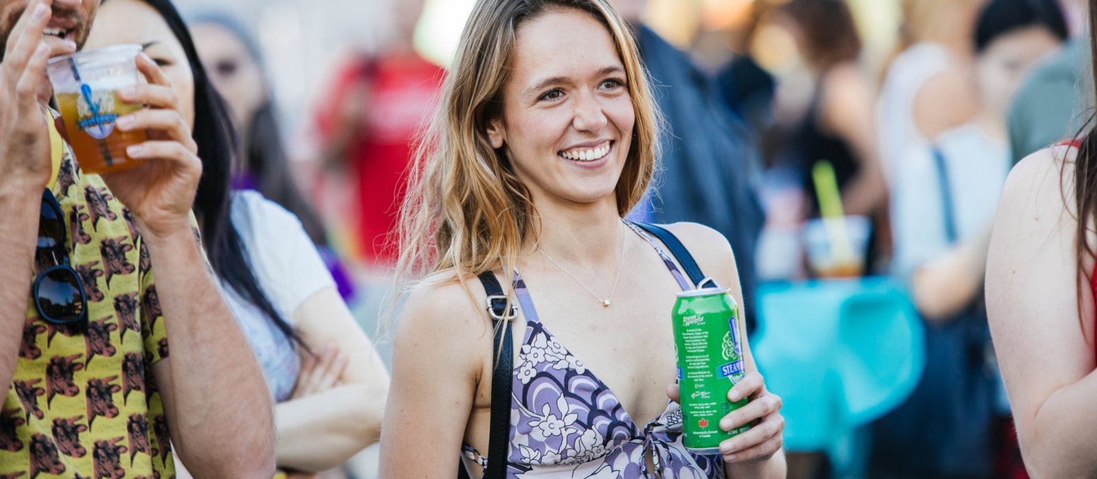 A young woman enjoys a Steam Whistle beer at the patio